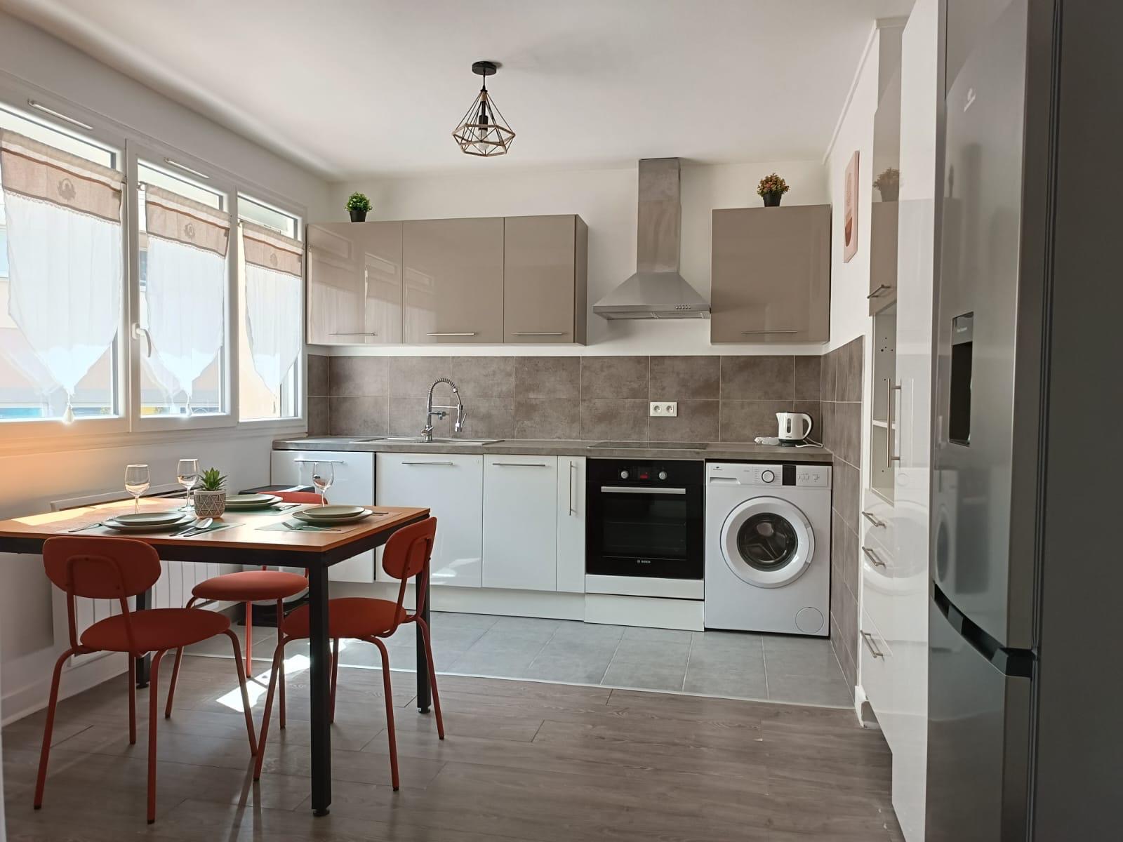 Cuisine rénovée avec table à manger et chaises orange