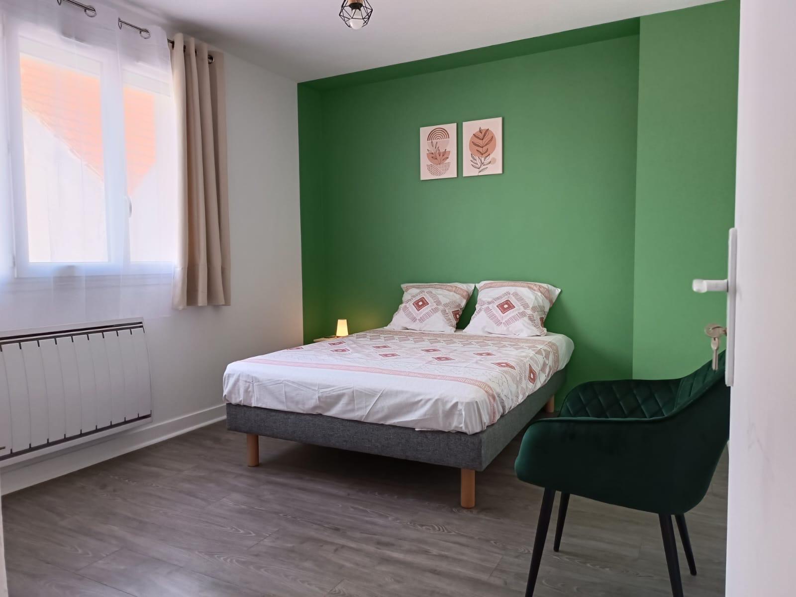 Chambre avec mur vert et lit double