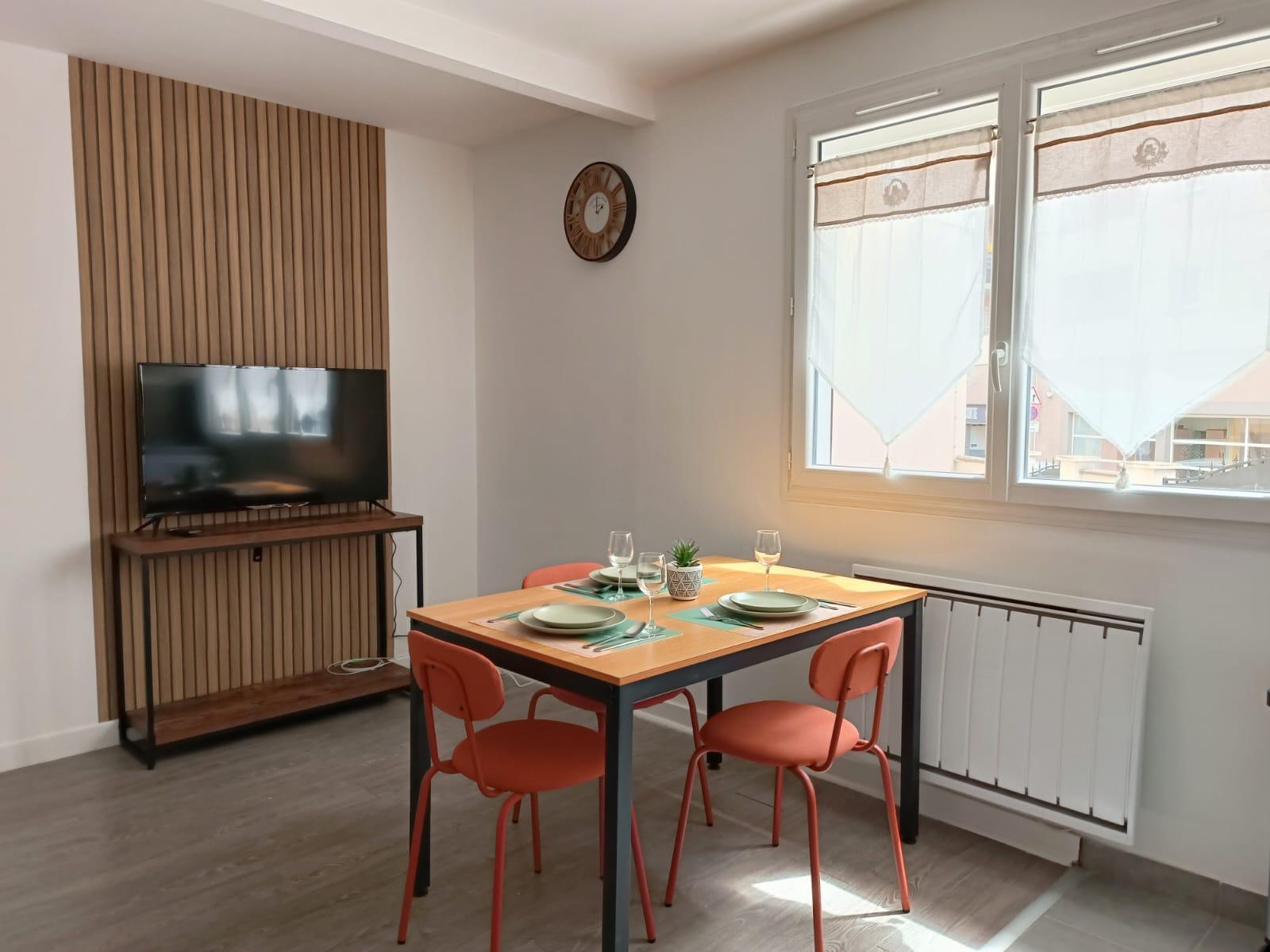 Séjour lumineux avec mur en tasseaux de bois et grandes fenêtres